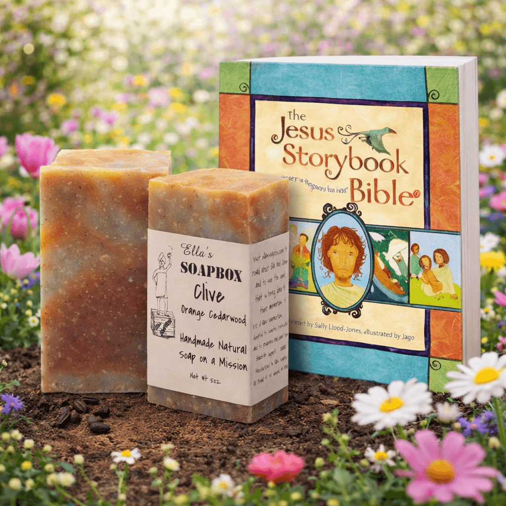Two bars of Clive's Orange Cedarwood soap beside The Jesus Storybook Bible among spring flowers