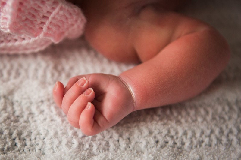 Close-up of Ella's tiny hand resting on a white blanket